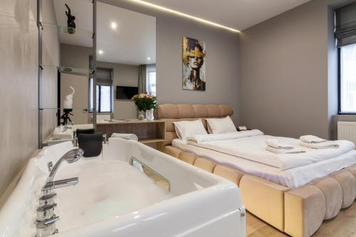 a bathroom with a tub and a bed and a sink at Royal jacuzzi apartment on Krehivska 10 st in Lviv