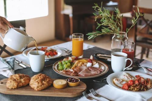 una mesa con platos de desayuno y una tetera en Butjani Lodge, en Cullinan