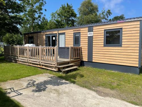 a tiny house with a porch and a deck at Ferienhaus im Naturschutzgebiet in Holland in Lauwersoog
