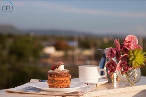 a table with a cake and a cup of coffee at CEU PALMAS Hotel in Palmas