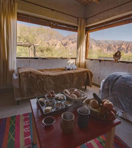 a room with a table with a tray of food on it at Otro Mundo alojamiento in Maimará