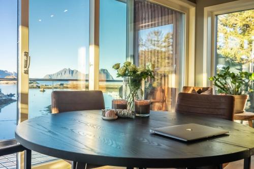 mesa de comedor con ordenador portátil encima en Lofoten Oceanfront Panoramic, en Kabelvåg