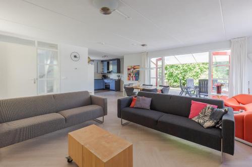 ein Wohnzimmer mit zwei Sofas und einem Tisch in der Unterkunft Duinvilla Deluxe met Sauna en Whirpool - 6 personen in Holle Poarte