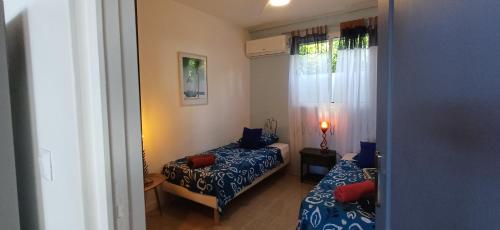 a small room with a bed and a window at Gîtes Capra Pomme Surette piscine et spa in Bouillante