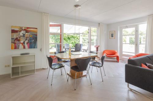 ein Wohnzimmer mit Tisch und Stühlen in der Unterkunft Duinvilla Deluxe met Sauna en Whirpool - 6 personen in Holle Poarte