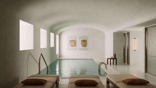 a swimming pool with two beds in a room at Palacio De Godoy Caceres, Curio Collection By Hilton in Cáceres