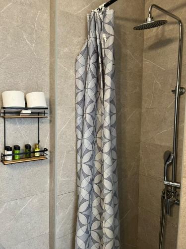 a shower with a shower curtain in a bathroom at Laertis Apartments -By NOMA STAYS Cyprus in Paphos