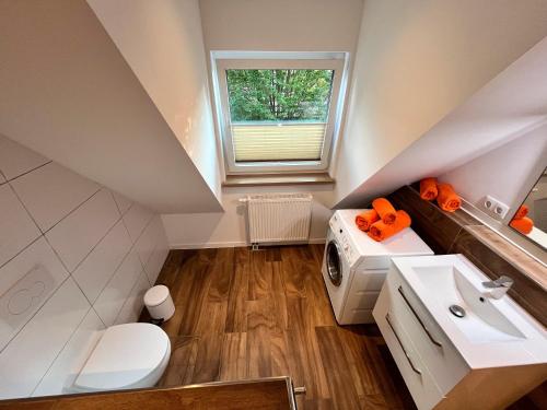 a attic bathroom with a sink and a washing machine at Ferienwohnung Seeblick in Bad Bodenteich