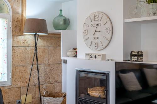 a clock on a wall next to a fireplace at Villa Fina in Colònia De Sant Jordi
