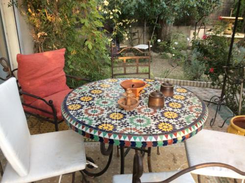 une table avec un motif floral sur la terrasse dans l'établissement La Roseraie Camarguaise, à Arles