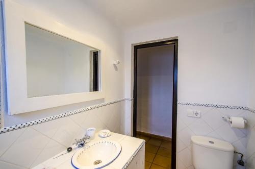 un bagno con un water, un lavandino e uno specchio di Villa Bini Andu a Binibeca