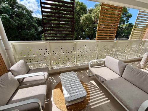 a balcony with a couch and chairs and a table at Cosy Sand plages et nature in Étang-Salé