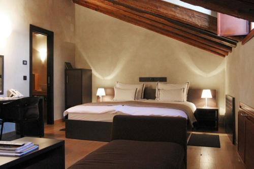a bedroom with a large bed and a desk at Heritage Hotel Kukuriku in Kastav