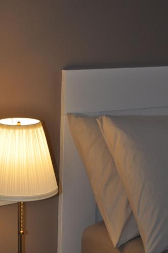 a lamp sitting next to a bed with a pillow at La Terrazza di Luca in Tavernelle