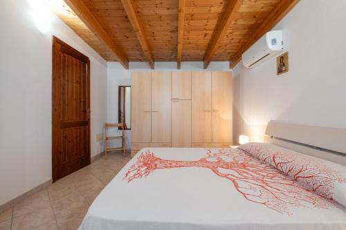 a bedroom with a bed and a wooden ceiling at Casa Silvia in Calasetta