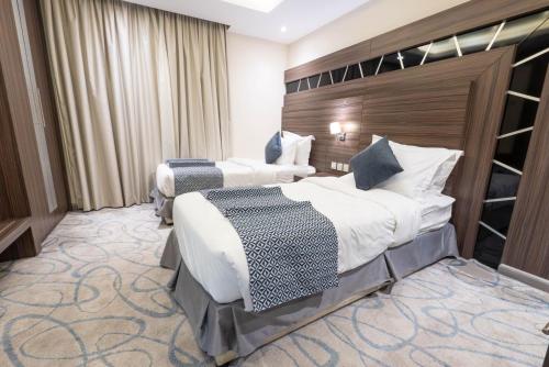 a hotel room with two beds and a wall at Sumou Al Khobar Corniche in Al Khobar