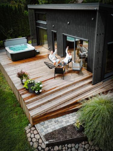 a house with a deck with a swimming pool at Villa Lakstīgalas Lux in Skrīveri