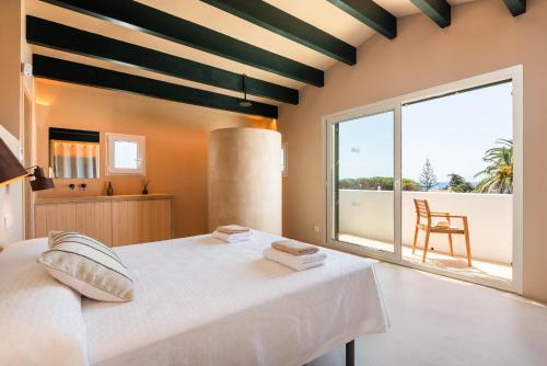 a bedroom with a white bed and a large window at Binimadi in Binisafua