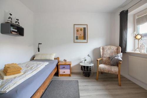 une chambre avec un lit, une chaise et une fenêtre dans l'établissement Ferienwohnung Achtern Diek, à Hillgroven