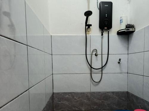 a bathroom with a shower with a phone on the wall at RZ HOMESTAY With WiFi in Sungai Siput