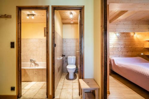 y baño con aseo, cama y bañera. en Studio Chénives - Morzine, en Morzine