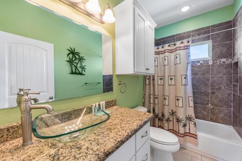 Un baño con lavabo, inodoro y ducha. en Shore Havin Fun, en Mustang Beach