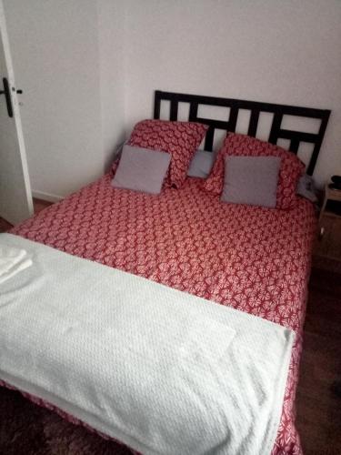 a bedroom with a large bed with red and white sheets at Chambre pour une personne in Blois