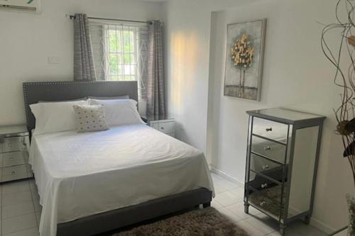 - une chambre blanche avec un lit et une table de nuit dans l'établissement 1 Bed Apartment Sleeps 4 with Free Parking, à Kingston