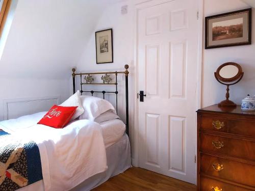 a bedroom with a bed with a red pillow on it at Castle View Suite - Corvesgate Cottage - 3 room suite in Corfe Castle