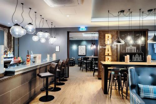a restaurant with a bar with chairs and tables at Premier Inn Berlin City Süd in Berlin
