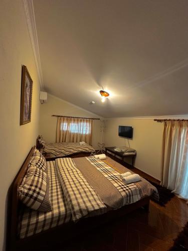 a bedroom with a large bed with a plaid blanket at Twins in Korçë