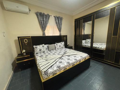 a bedroom with a bed and a large mirror at Residence FATIMA in Thiès