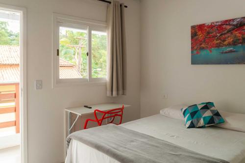 une chambre avec un lit, un bureau et une fenêtre dans l'établissement Pousada Uchimura, à Itapecerica da Serra