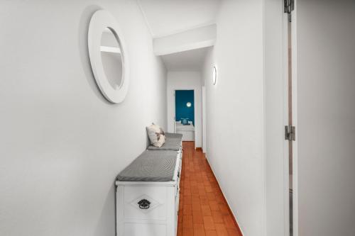 a hallway with white walls and a mirror on the wall at Casa Indie in Burgau