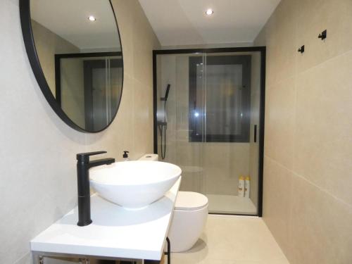 a bathroom with a sink and a toilet and a mirror at Myholidayshome in Palamós