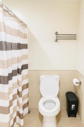 a bathroom with a toilet and a shower curtain at Studio Persimmon condo Mabolo cebu city in Cebu City