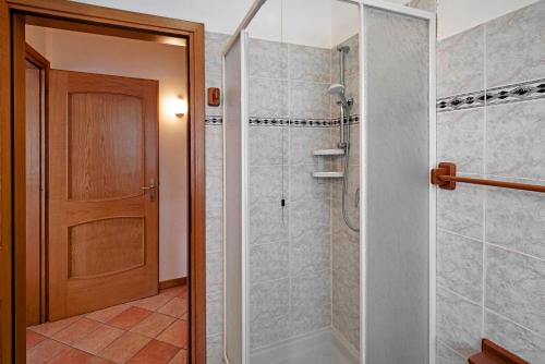 Un baño con ducha y puerta de cristal. en Residence Malibu Appartamento 1, en Falcade