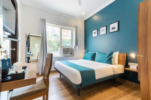 um quarto com uma cama e uma parede azul em Hotel King Near Delhi Airport em Nova Deli