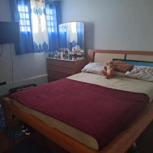 a bedroom with a bed with a teddy bear on it at Appartement confortable à Saint-Joseph avec piscine in Long-Bois