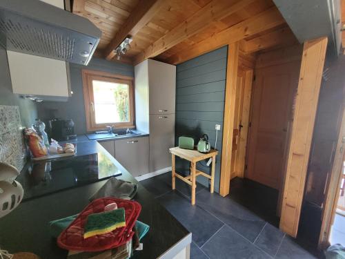 Chalet Chez Marius في لابريس: مطبخ مع أسطح عمل سوداء وباب خشبي