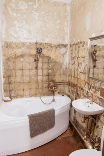 a bathroom with a bath tub and a sink at Jaunpils pils in Jaunpils