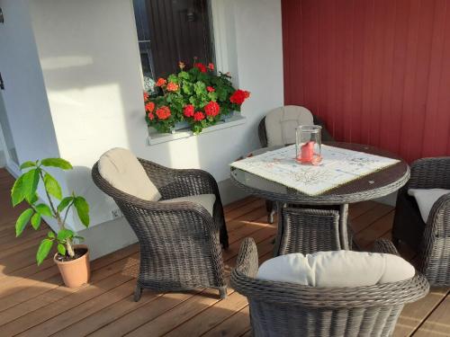 a patio with a table and chairs and flowers at Ferienwohnung am Schmenkenberg in Marsberg