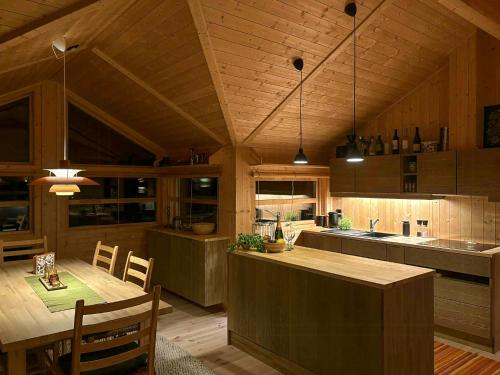 a large kitchen with a table and a dining room at Ål Cabin With Views Of Marshland And Mountains in Haglebu