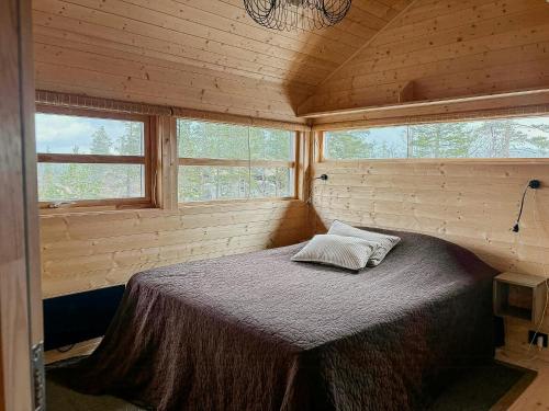 a bedroom with a bed in a wooden cabin at Ål Cabin With Views Of Marshland And Mountains in Haglebu