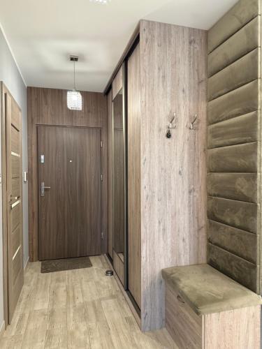 ein Flur mit Holzwänden und einer Holztür in der Unterkunft ApartamentywInie in Inowrocław