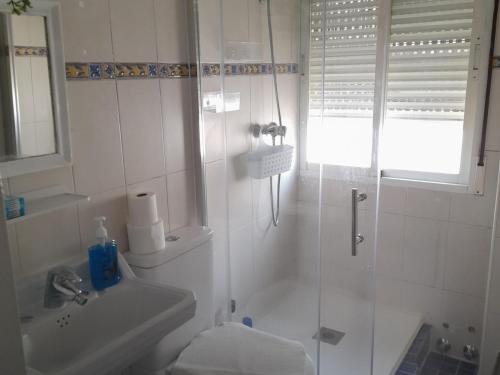 a white bathroom with a shower and a sink at A Beautiful Townhouse in Rute