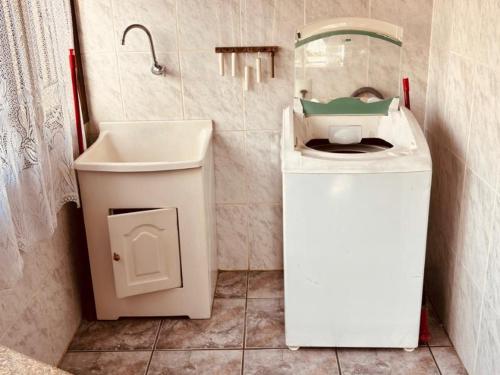 a bathroom with a sink and a washing machine at Experiência única em Bombinhas frente ao Mar. in Bombinhas