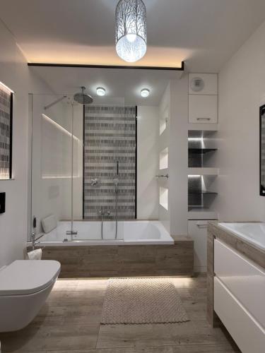 ein Badezimmer mit Badewanne, Toilette und Waschbecken in der Unterkunft ApartamentywInie in Inowrocław