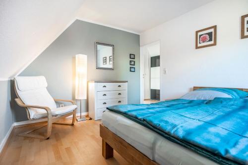 a bedroom with a bed and a chair at Waldgästehaus Externsteine in Horn-Bad Meinberg