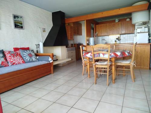 ein Wohnzimmer mit Couch und Tisch und eine Küche in der Unterkunft Appartement T2 Front de mer avec parking privatif - 4PC216 in Saint Cyprien Plage